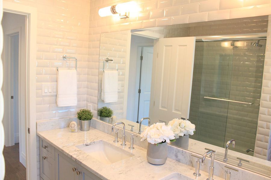 A bathroom with two sinks and a large mirror.