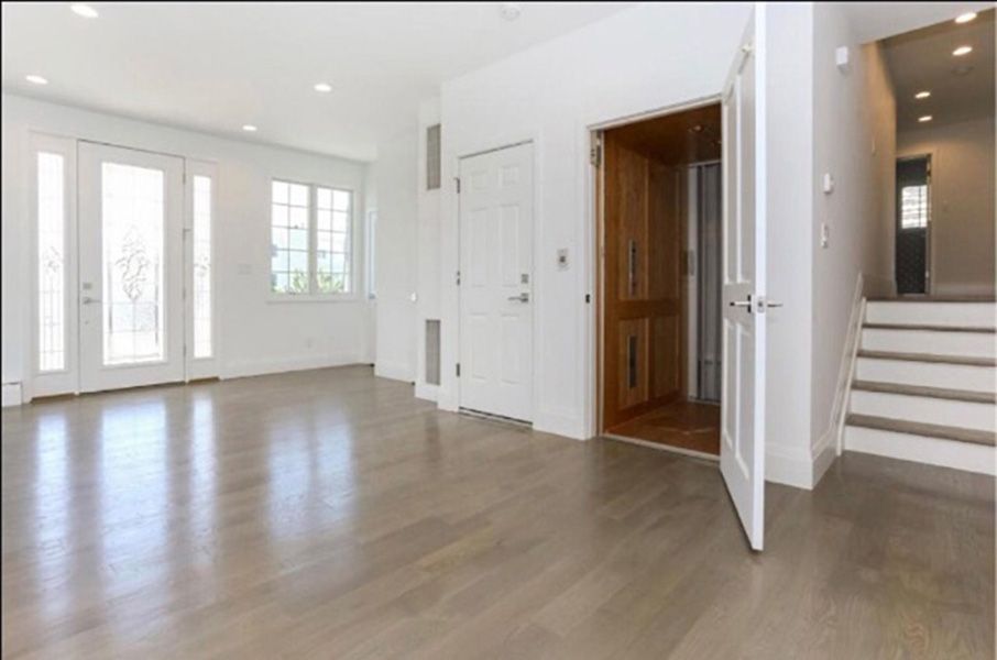 An empty living room with hardwood floors and stairs