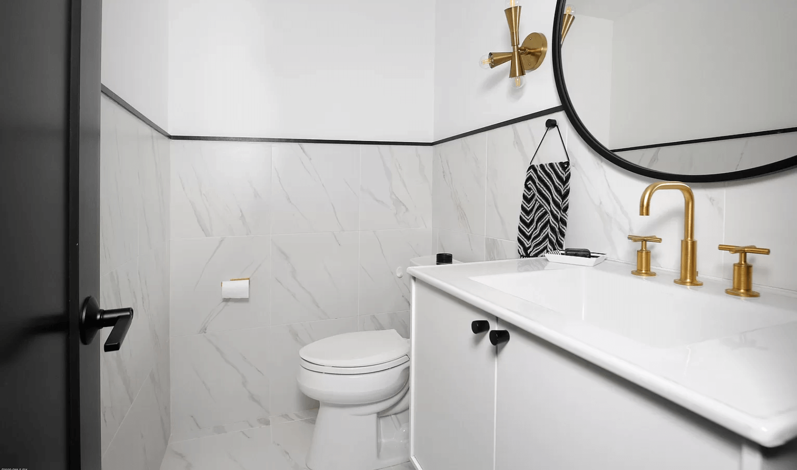 A bathroom with a toilet , sink and mirror.