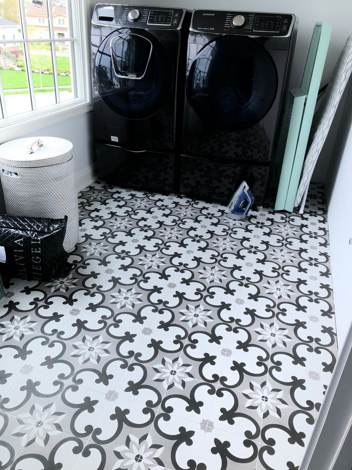 A laundry room with a washer and dryer and a black and white tile floor.
