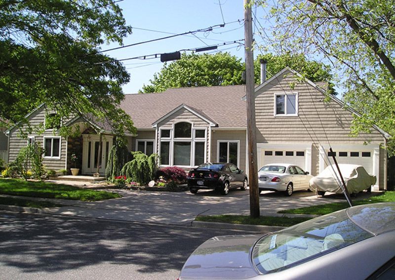 A house with two cars parked in front of it
