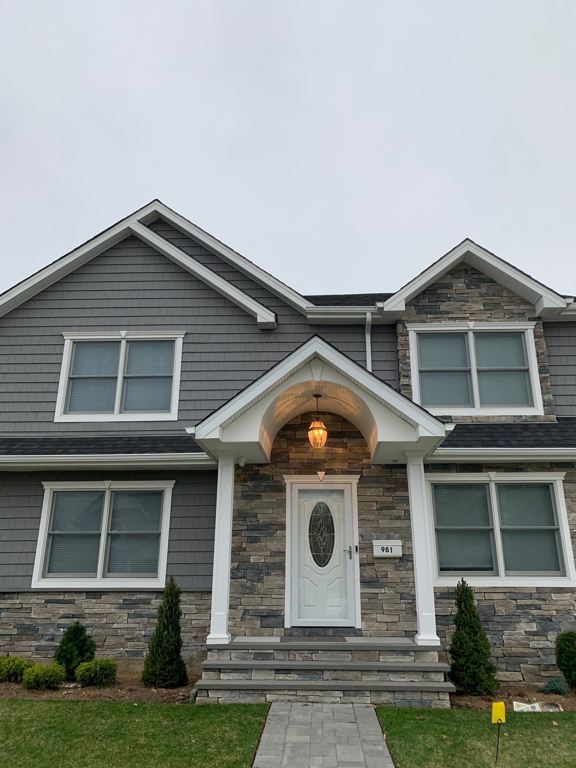 A large gray house with a white door and a porch.