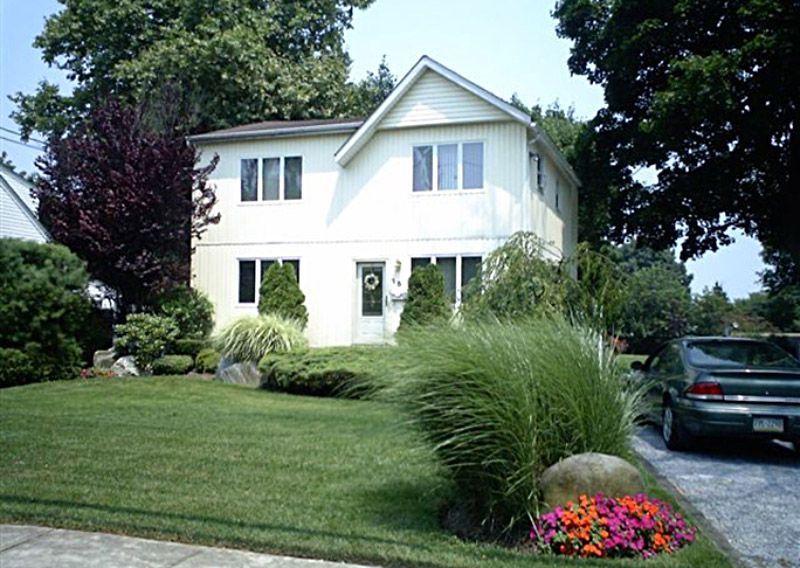 A white house with a car parked in front of it