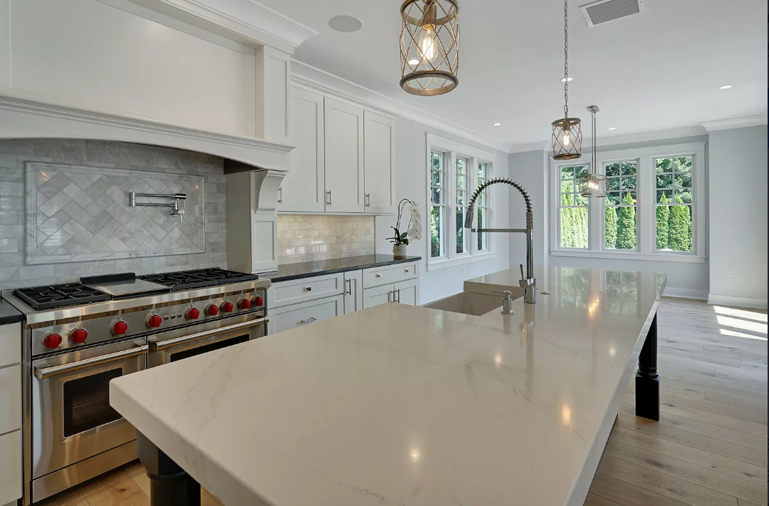 A kitchen with a large island , stove and sink