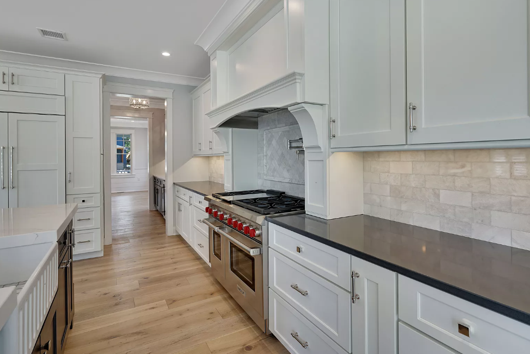 A kitchen with white cabinets and stainless steel appliances.