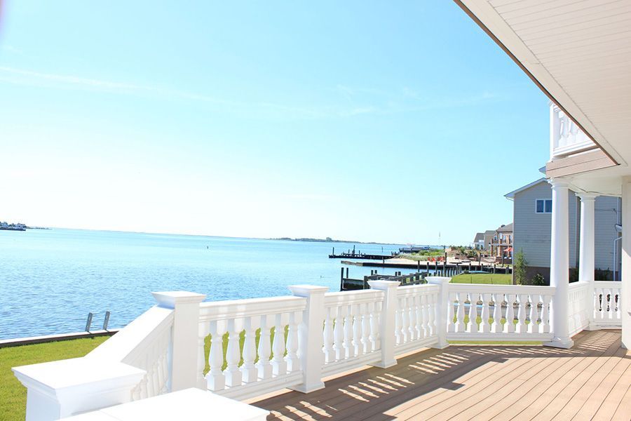 A balcony overlooking a body of water with a white railing