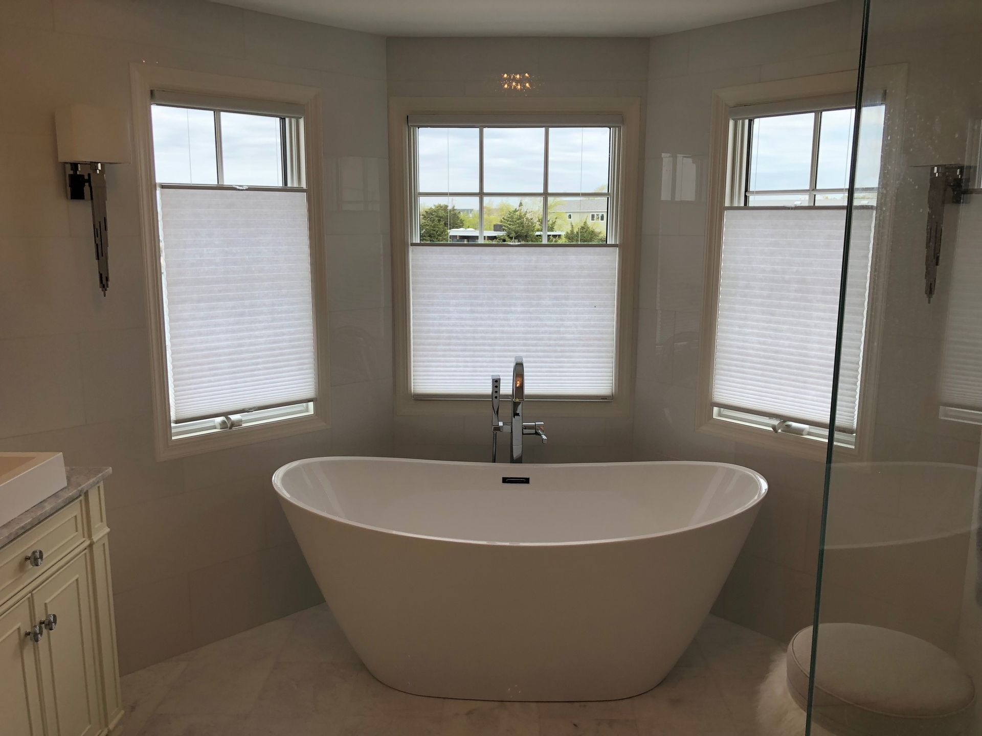 A bathroom with a bathtub and two windows