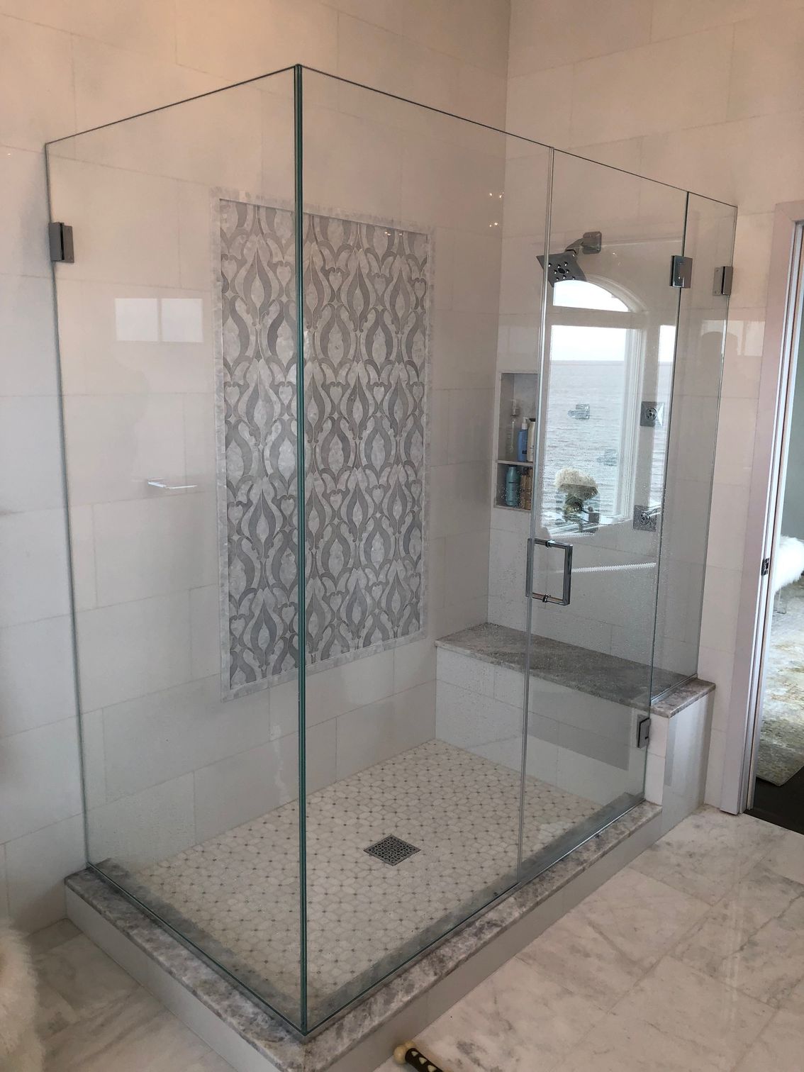 A bathroom with a walk in shower with a glass door.