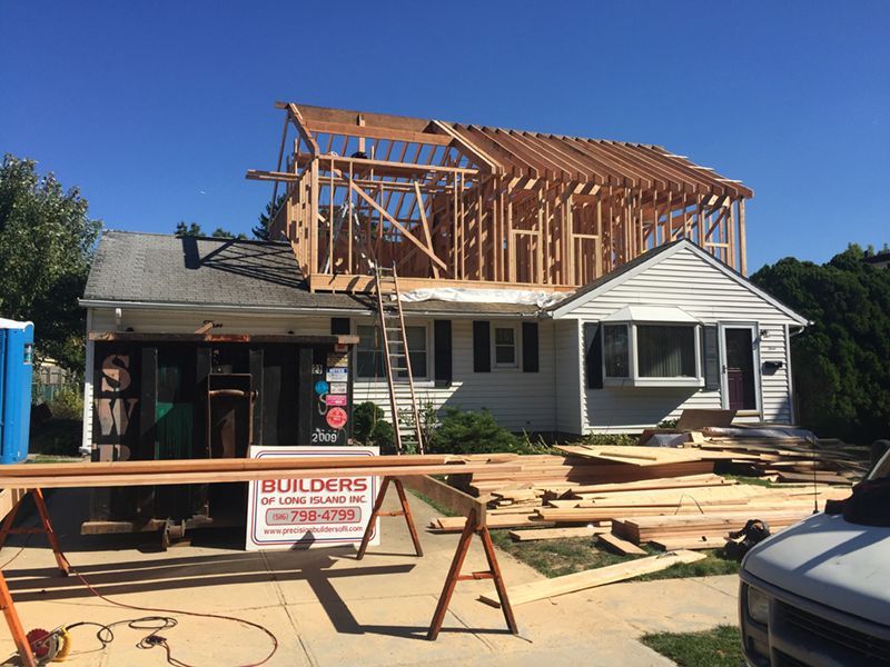 A house under construction with a builders sign in front of it