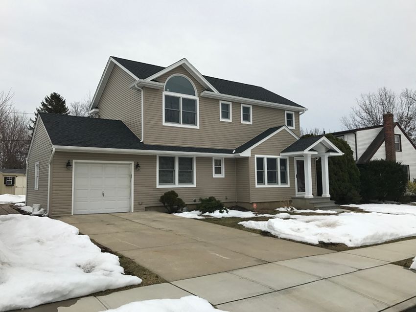 A house with snow on the ground and a garage