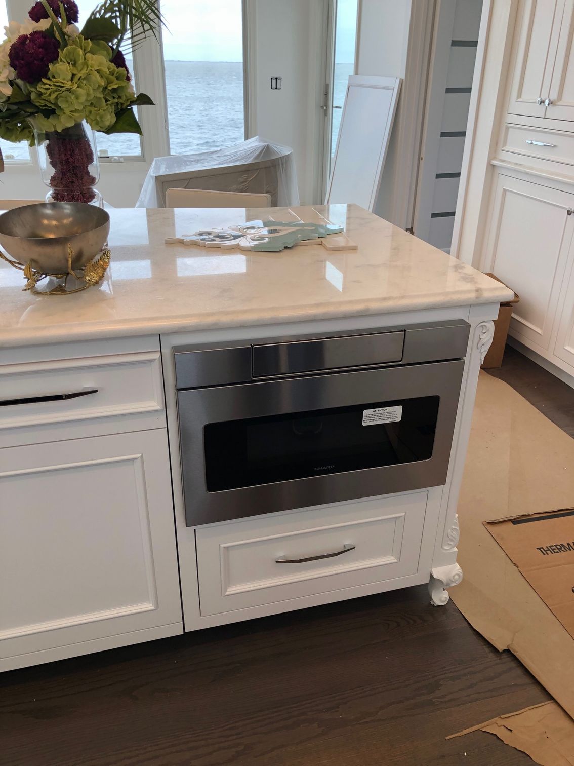 A kitchen with white cabinets and a stainless steel oven.