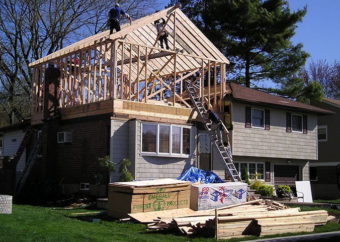 A house is being remodeled with a roof that is being built