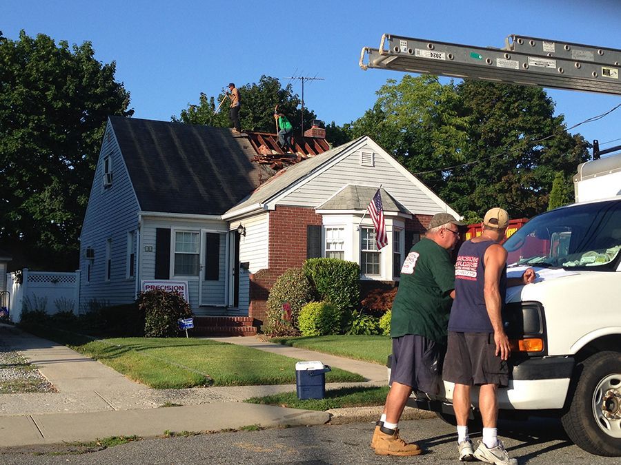 Two men standing next to a white van in front of a house