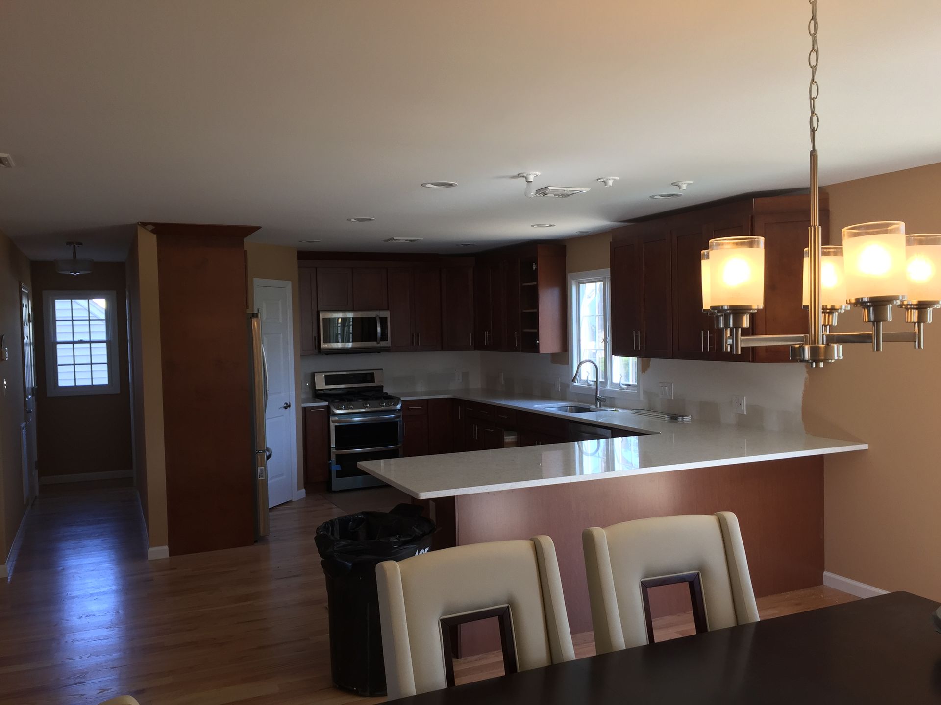 A kitchen with a table and chairs and a chandelier hanging from the ceiling