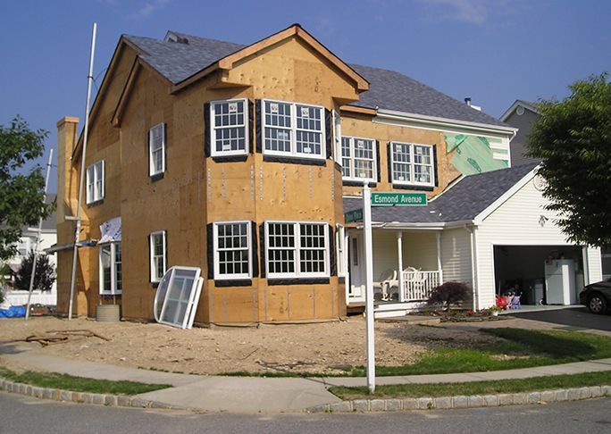 A house under construction with a street sign that says emanuel avenue