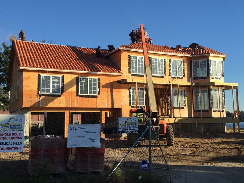 A large house that is being built with a roof that has a tile roof