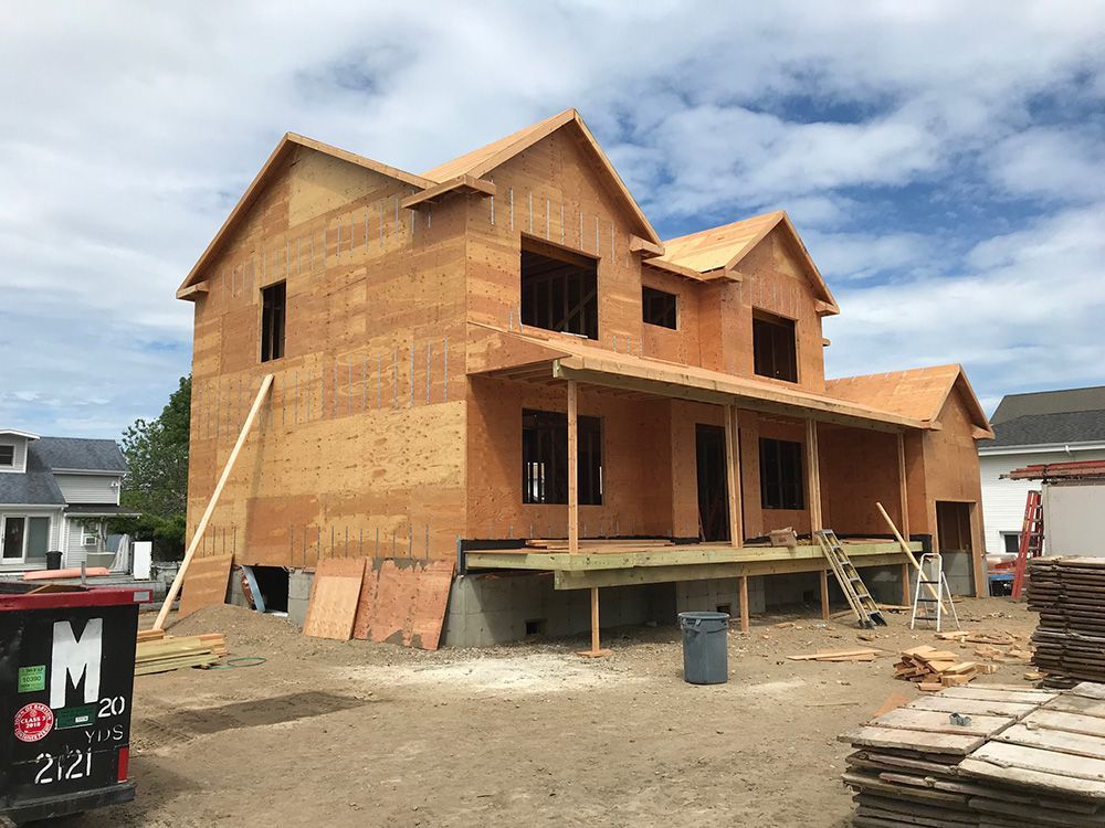 A house is being built with plywood and a porch.