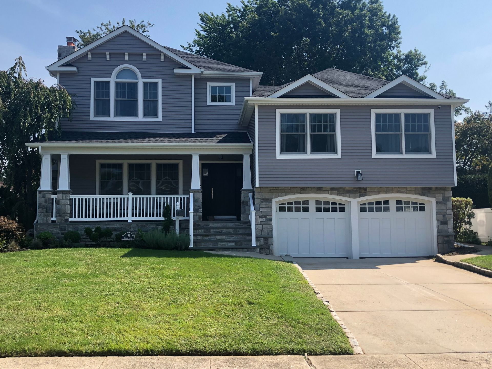 A large gray house with a white garage door