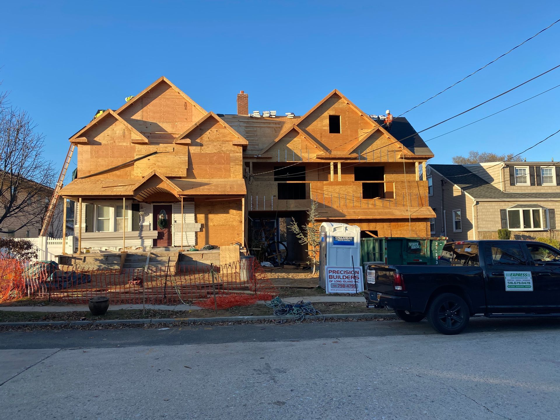 A truck is parked in front of a house under construction.