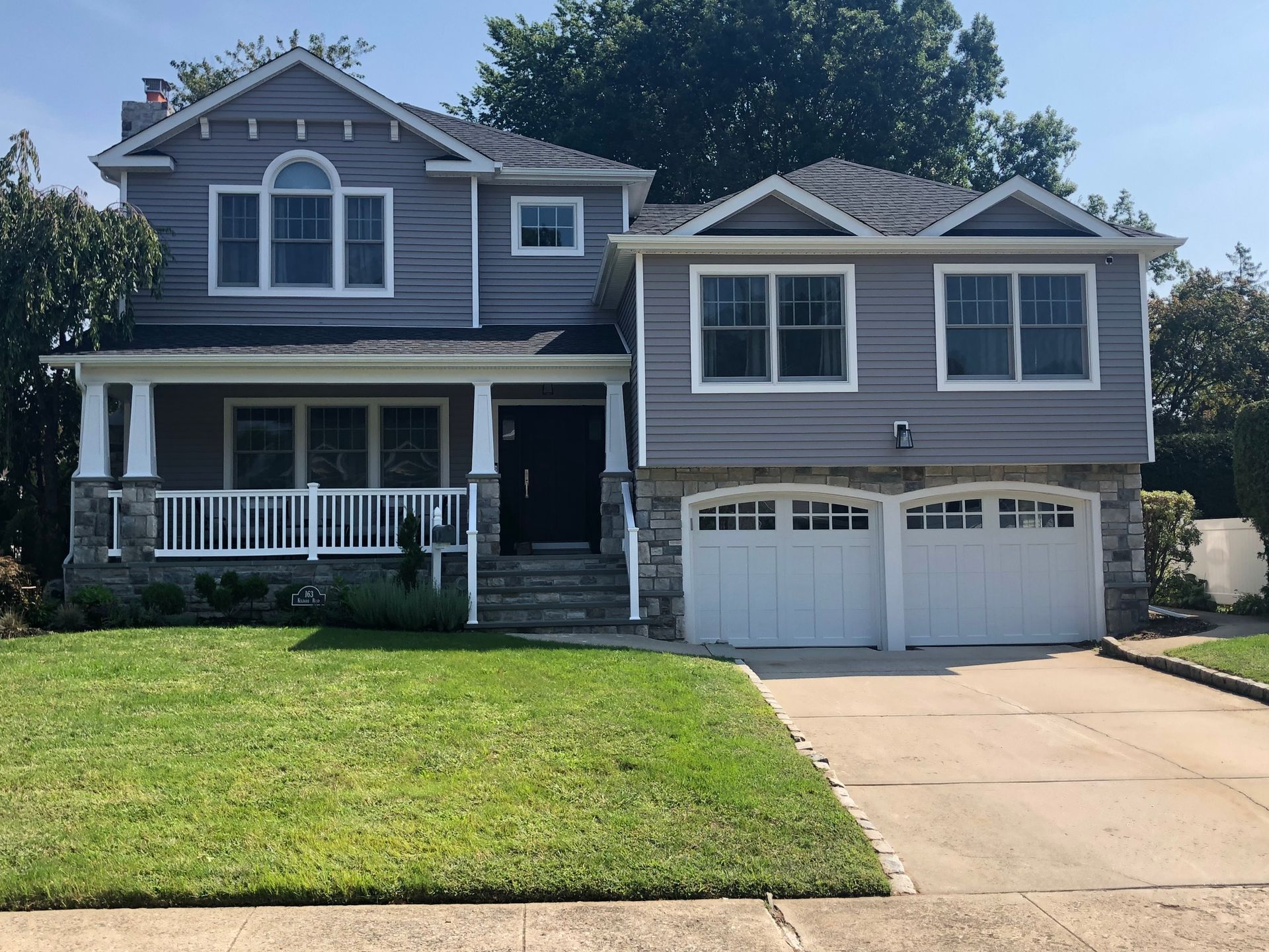 A large gray house with a white garage door