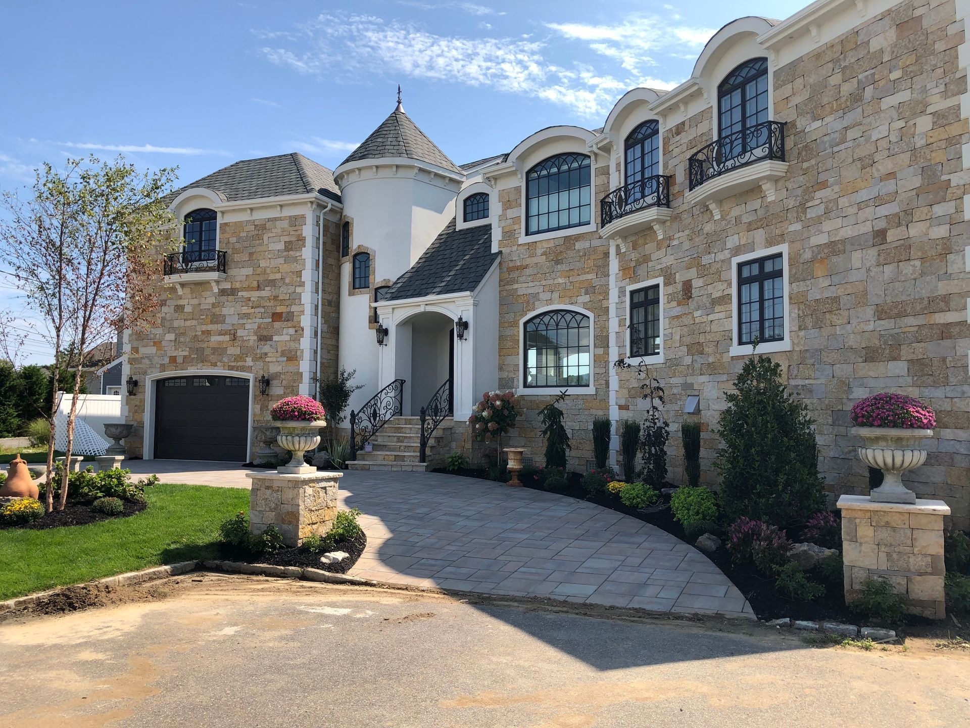 A large house with a lot of windows and a driveway leading to it.
