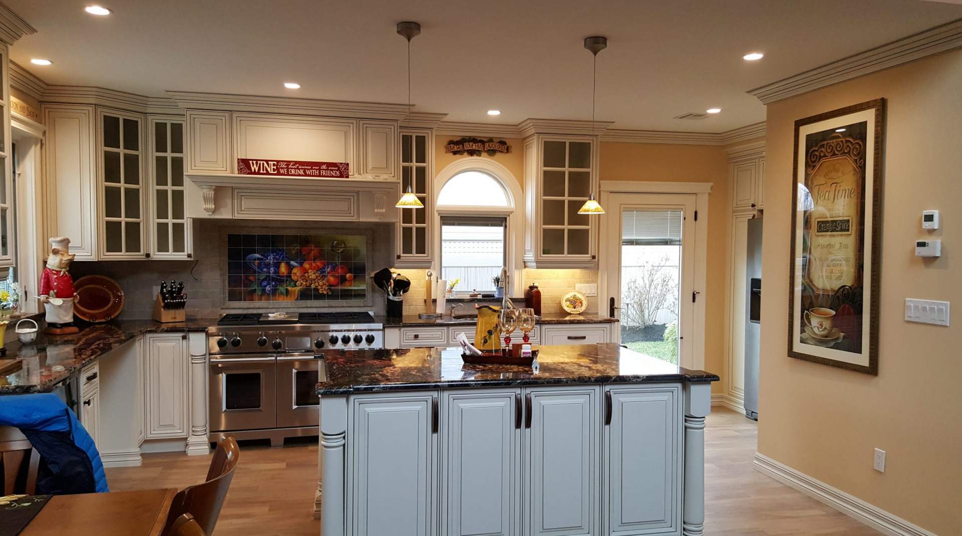 A kitchen with white cabinets and a large island in the middle.