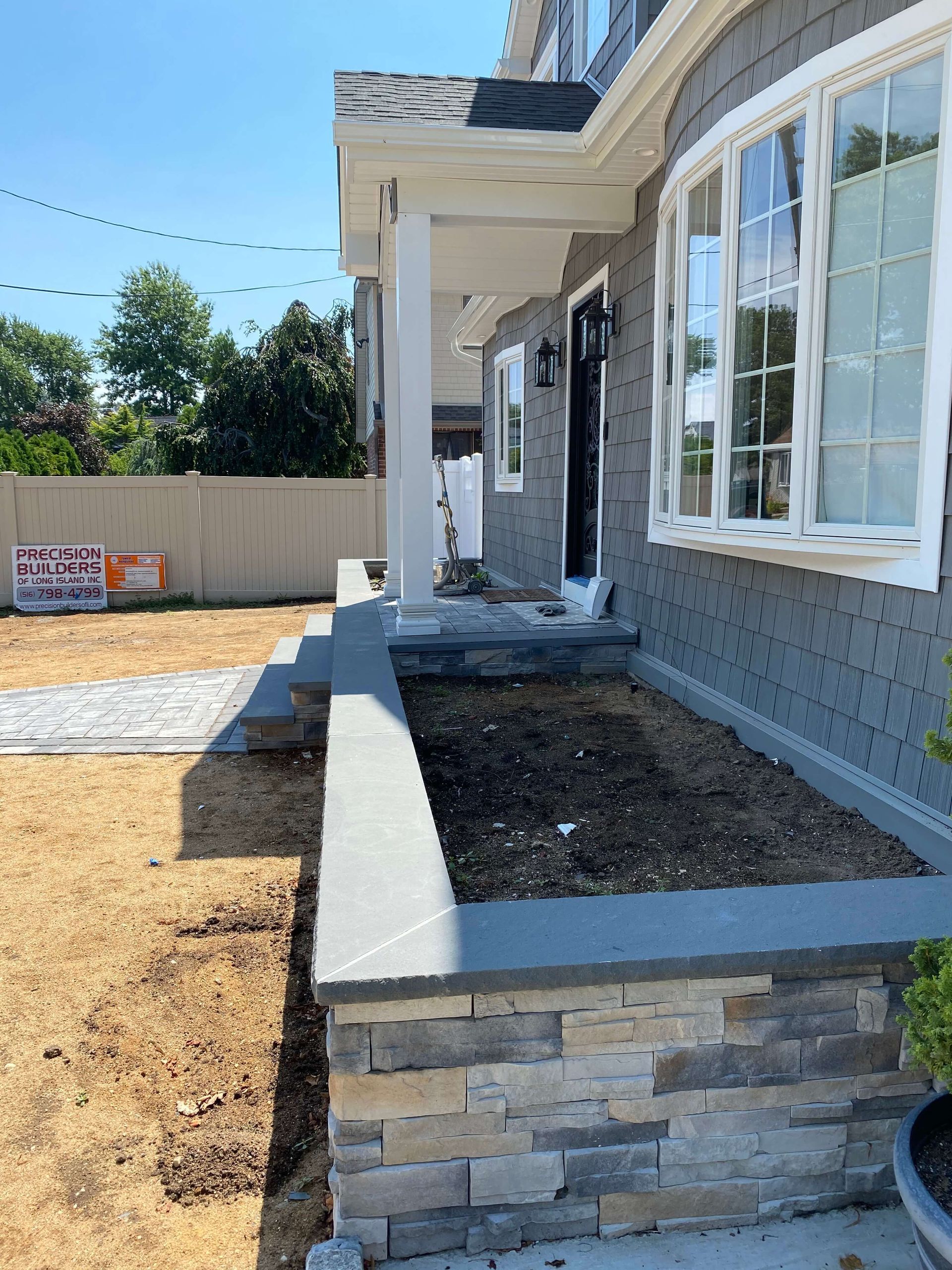 A gray house with a planter in front of it