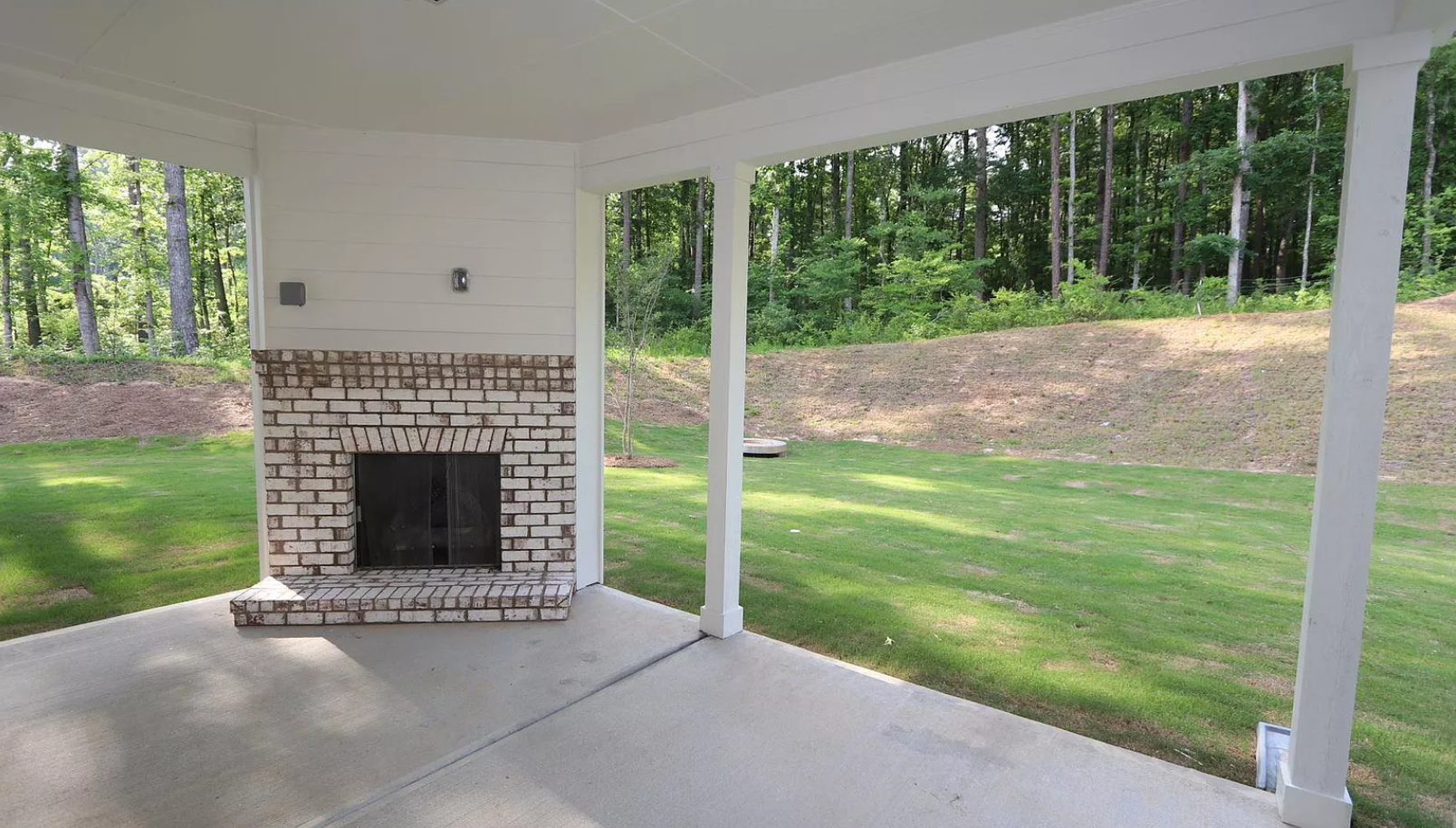 There is a fireplace in the backyard of a house.