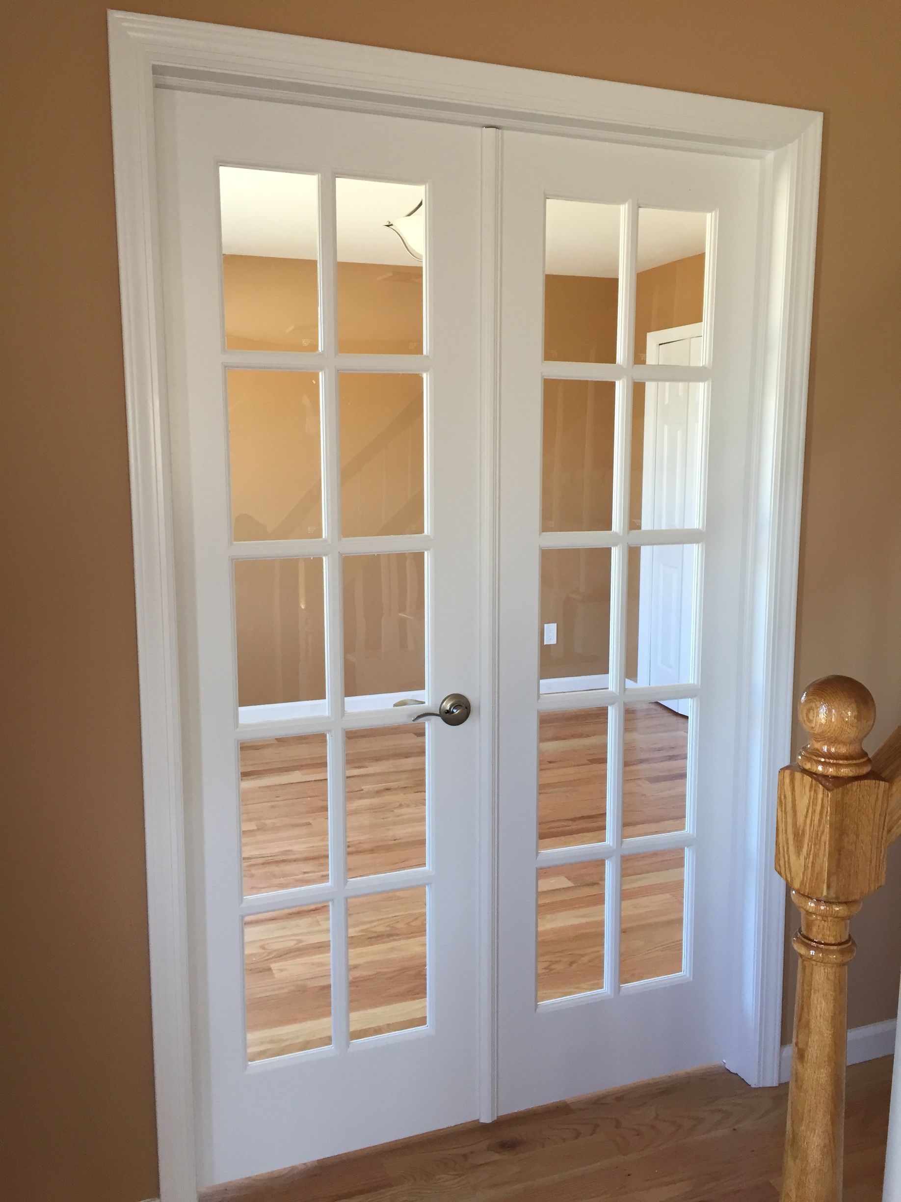 A pair of white french doors in an empty room
