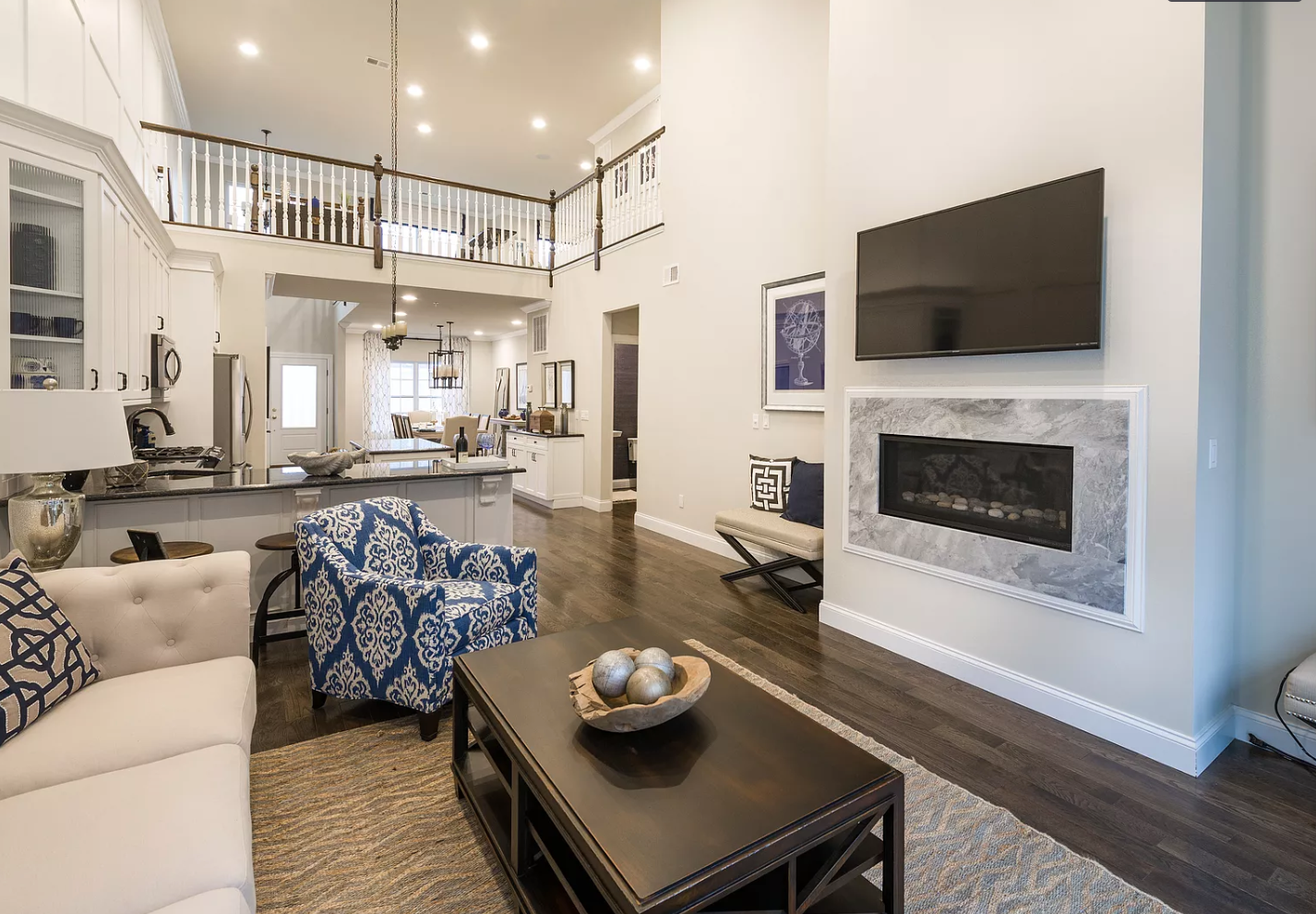 A living room with a couch , chair , coffee table and television.