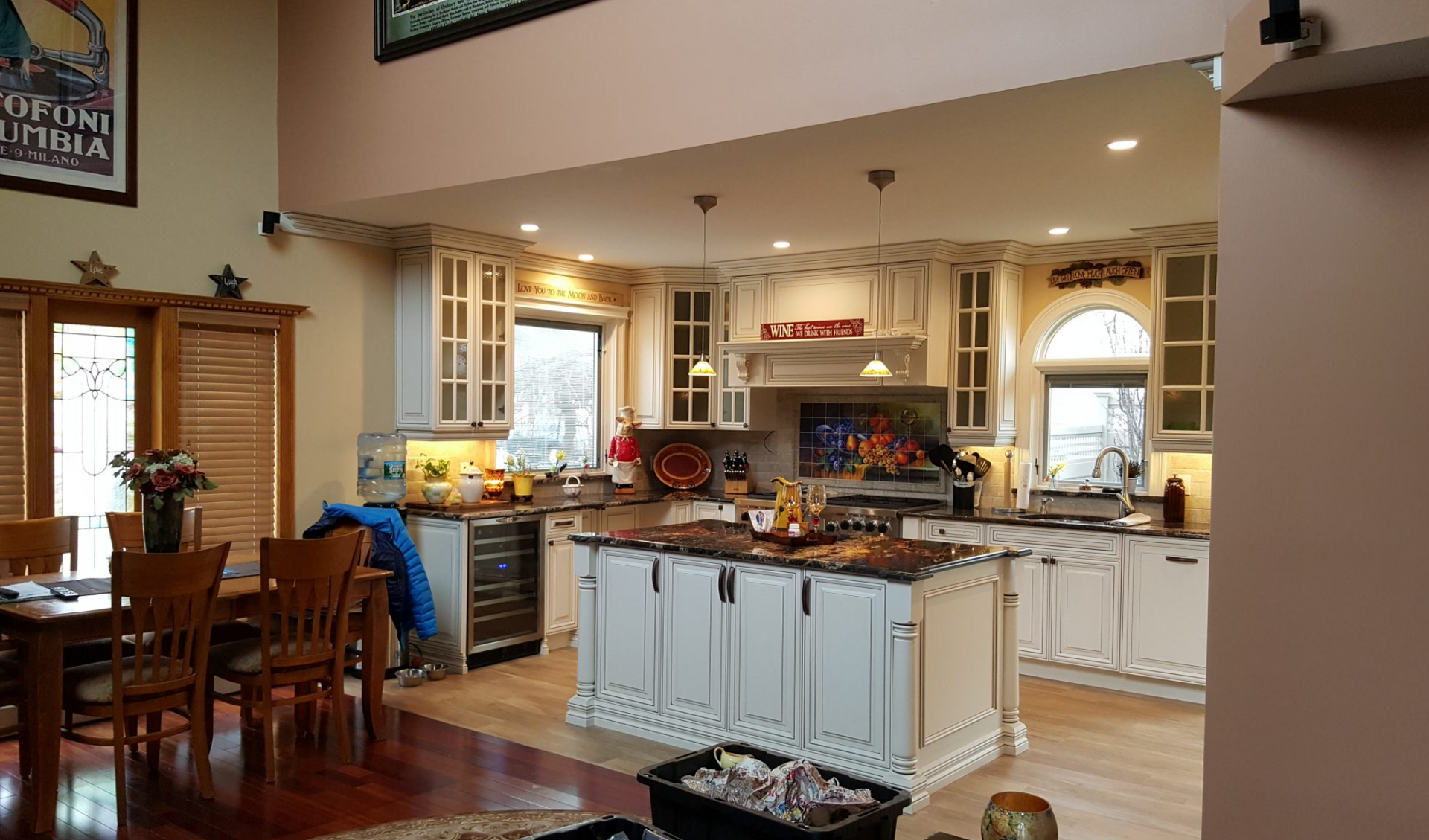 A kitchen with white cabinets and a large island in the middle of the room.