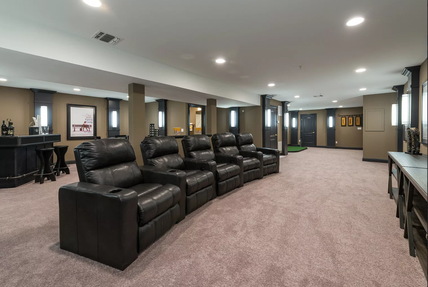 A large basement with a lot of chairs and a bar.