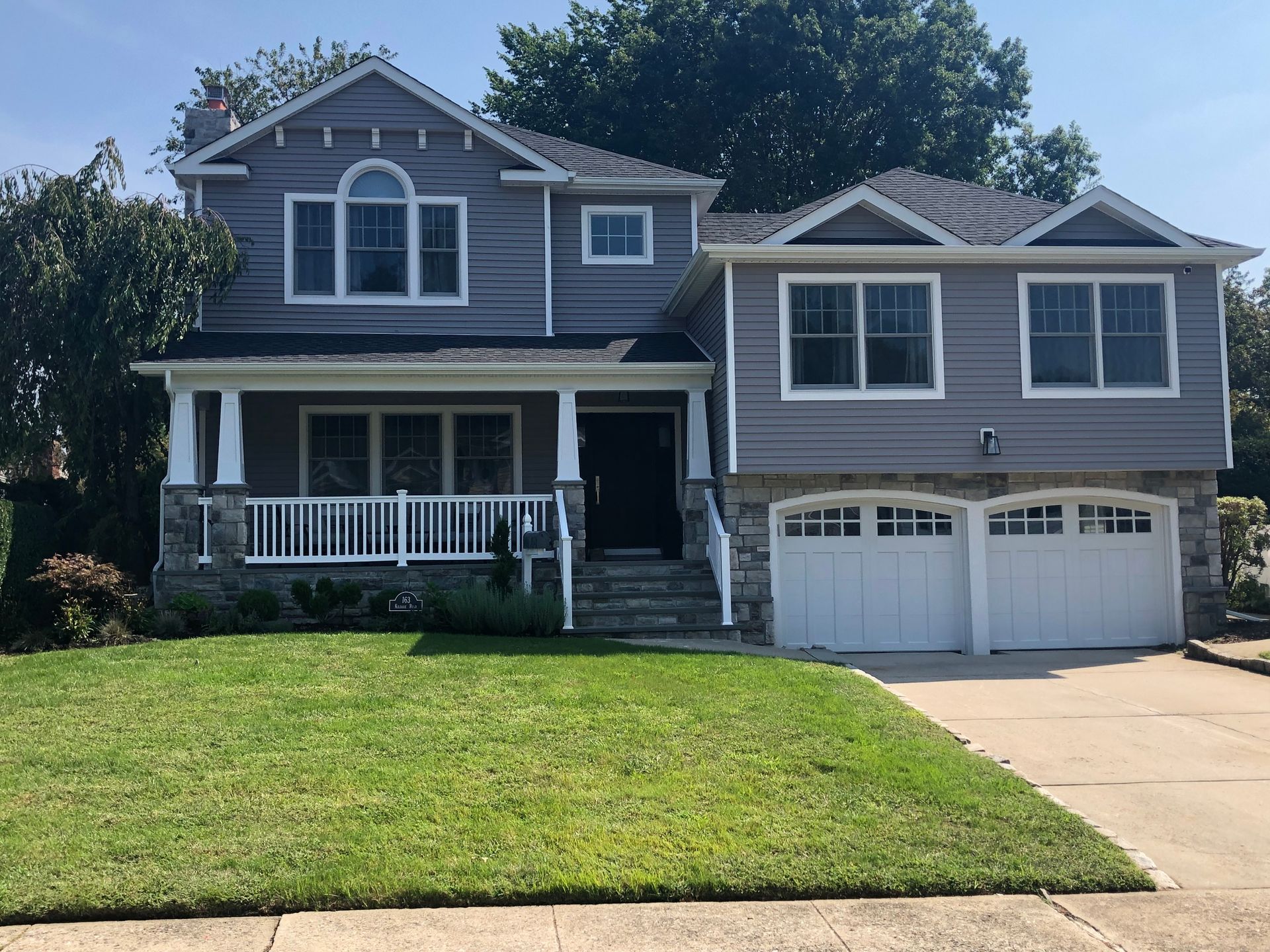 A large gray house with a white garage door