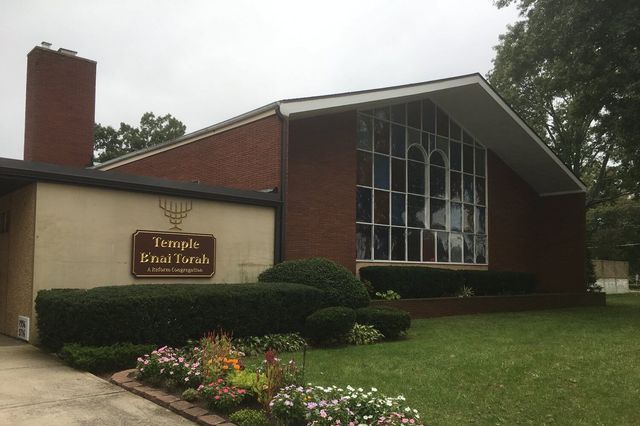 A large brick building with a sign that says temple emat torah