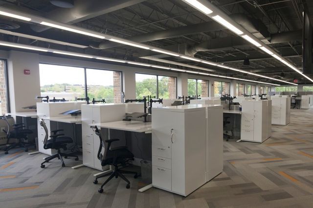 A large office with a lot of desks and chairs.