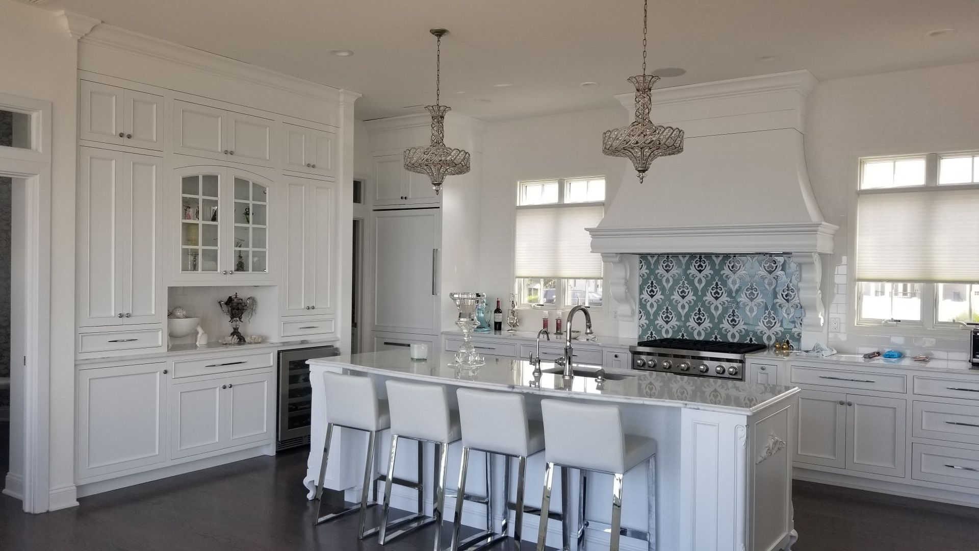 A large kitchen with white cabinets and a large island.