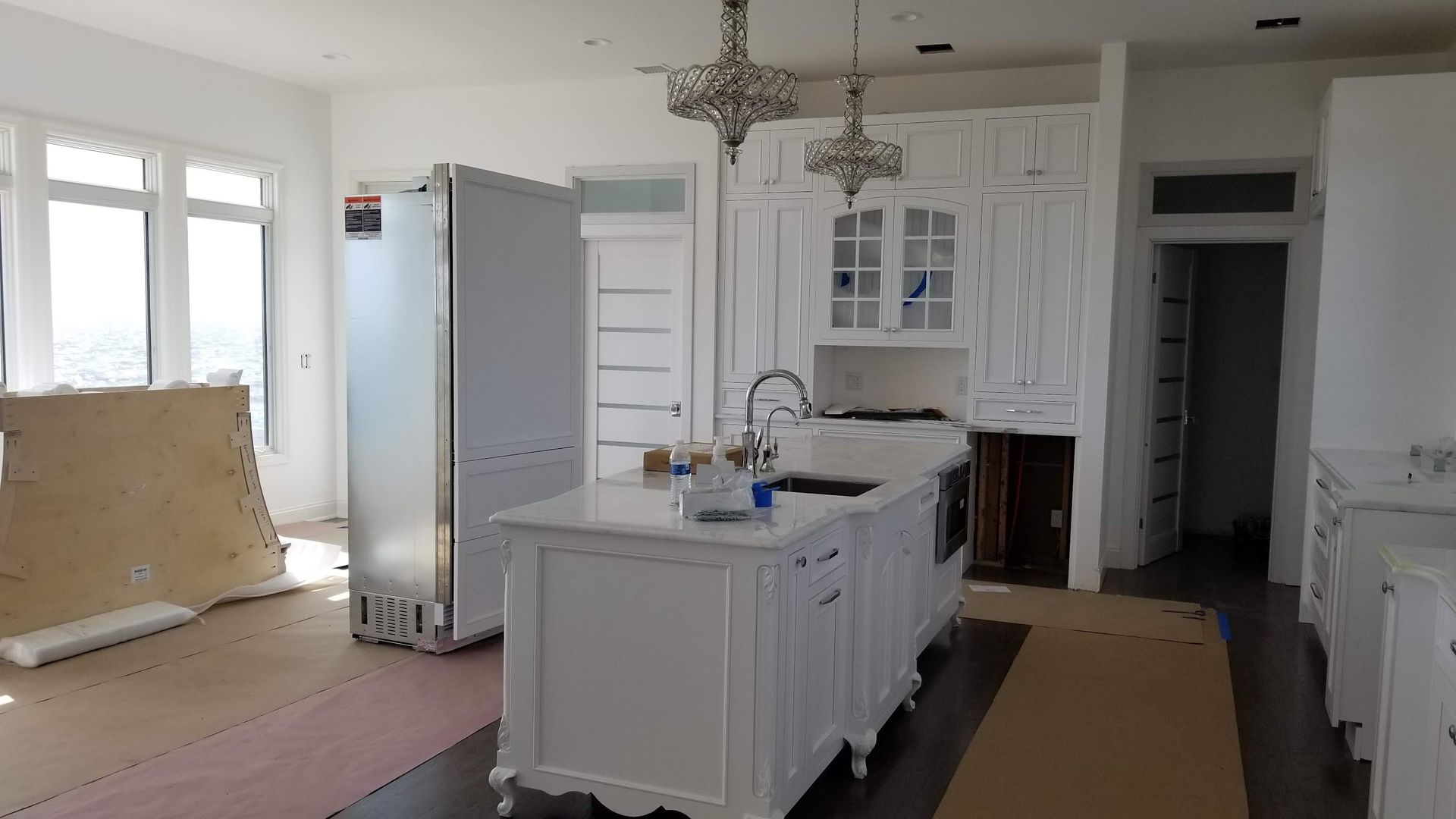 A kitchen with white cabinets and a large island in the middle.