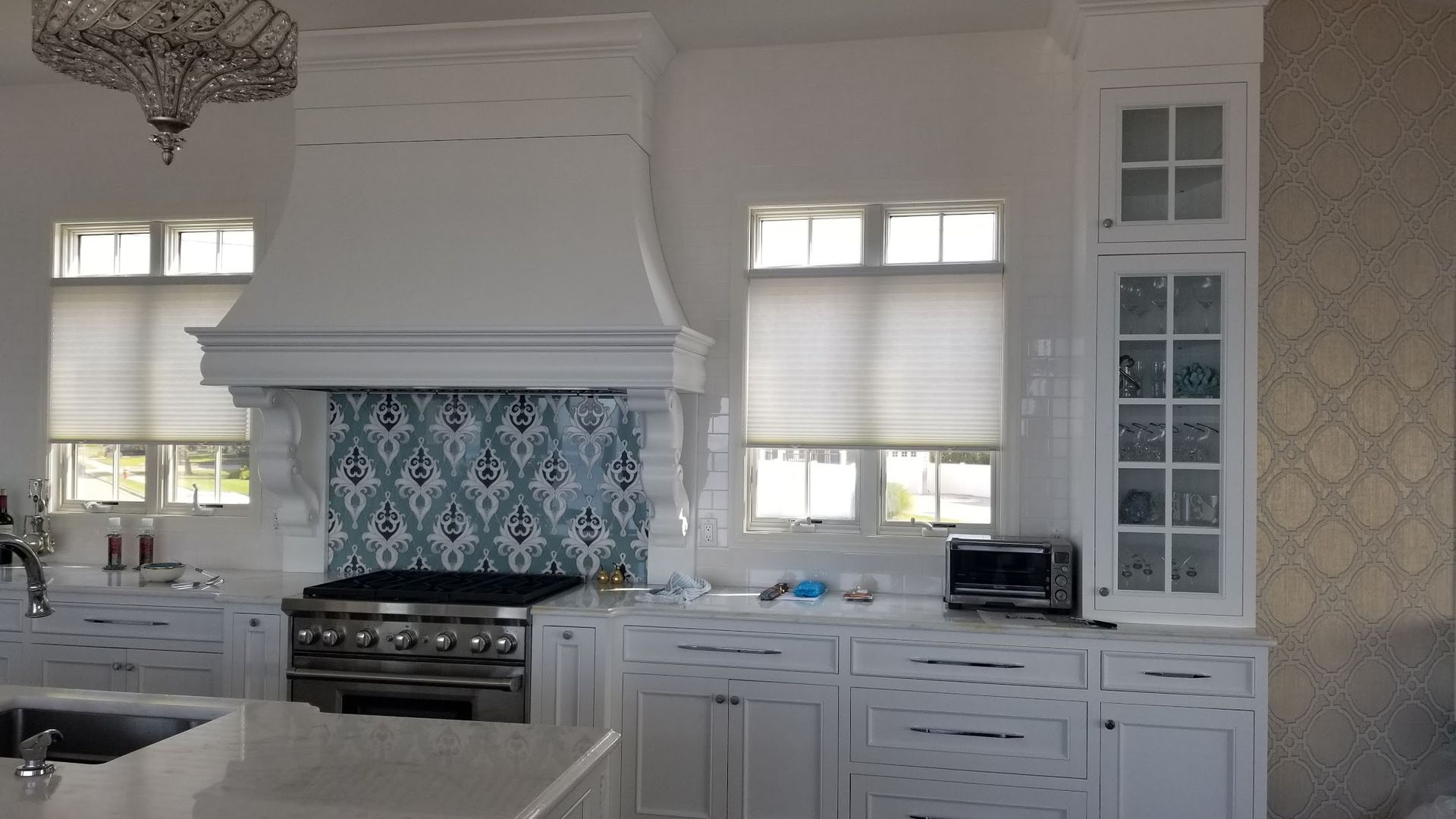 A kitchen with white cabinets and a stove top oven