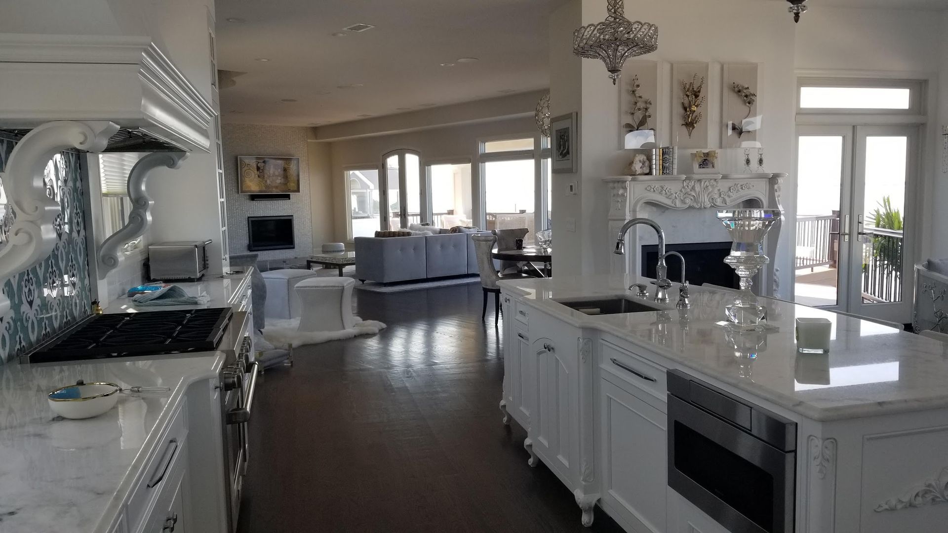 A kitchen with white cabinets and stainless steel appliances and a large island in the middle of the room.