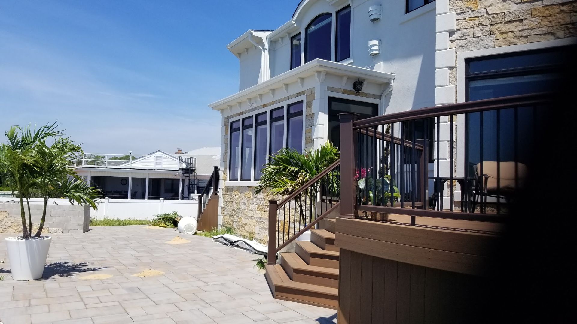 A large white house with a wooden deck and stairs