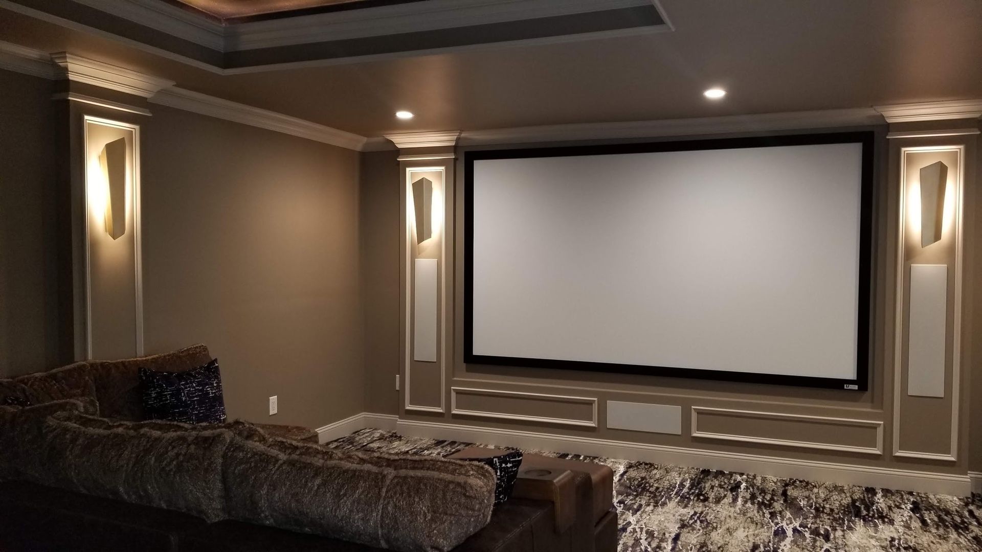 A home theater with a large screen and a couch.