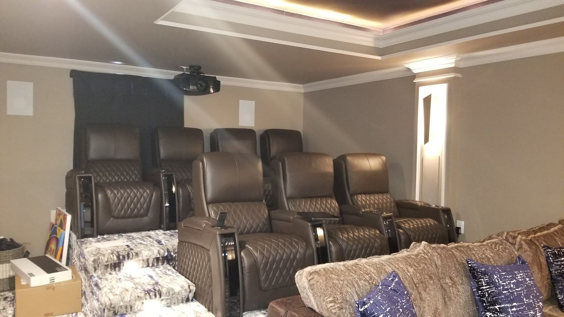 A home theater with a projector and reclining chairs
