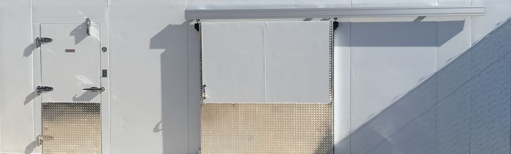 A white wall with a sliding door in the middle of it.