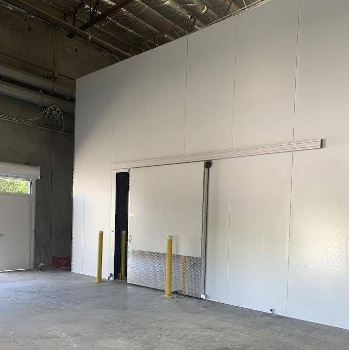 A large warehouse with a sliding door in the middle of it.