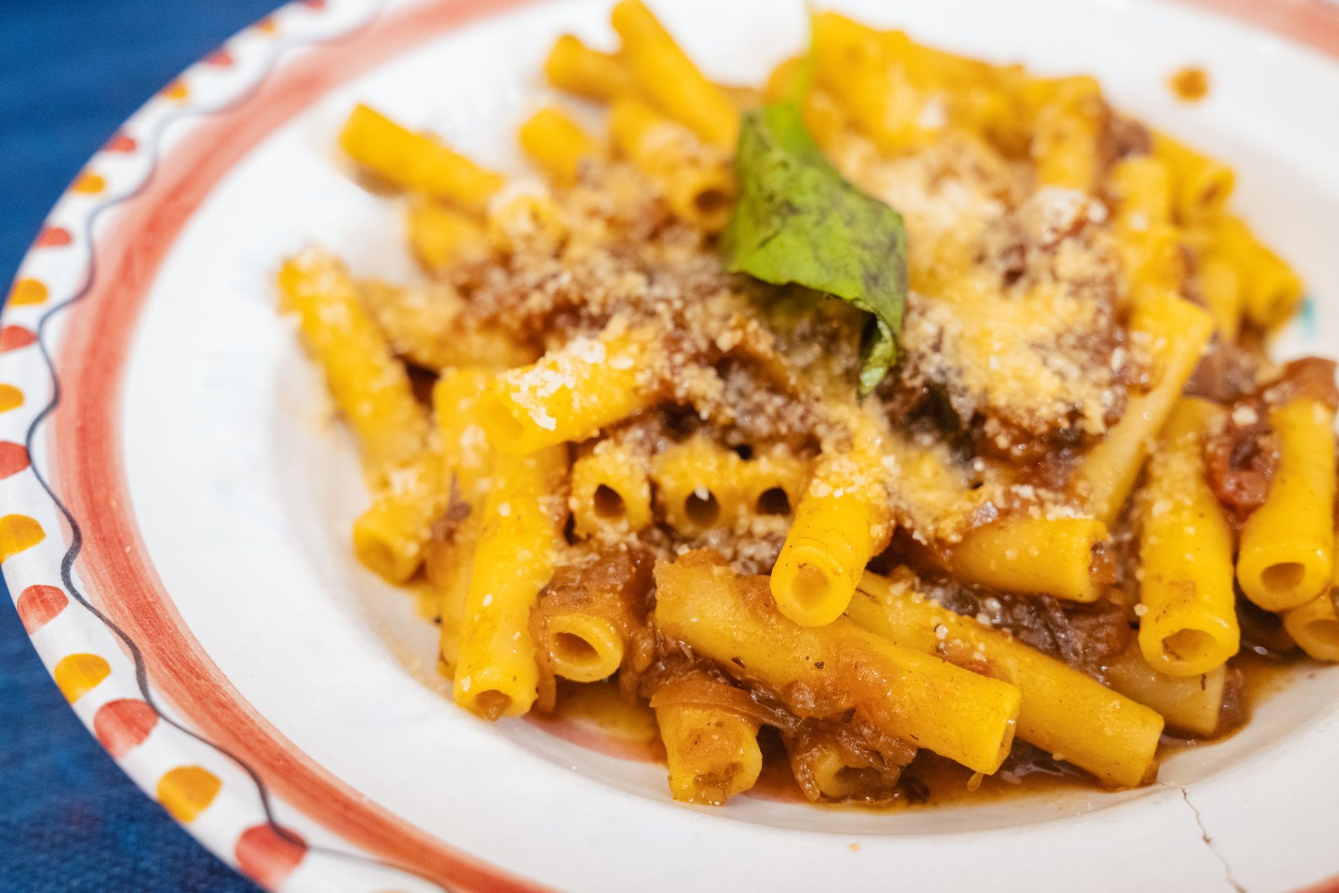 Interno di un ristorante con piante sospese, soffitto curvo e un cuoco che lavora dietro il bancone.