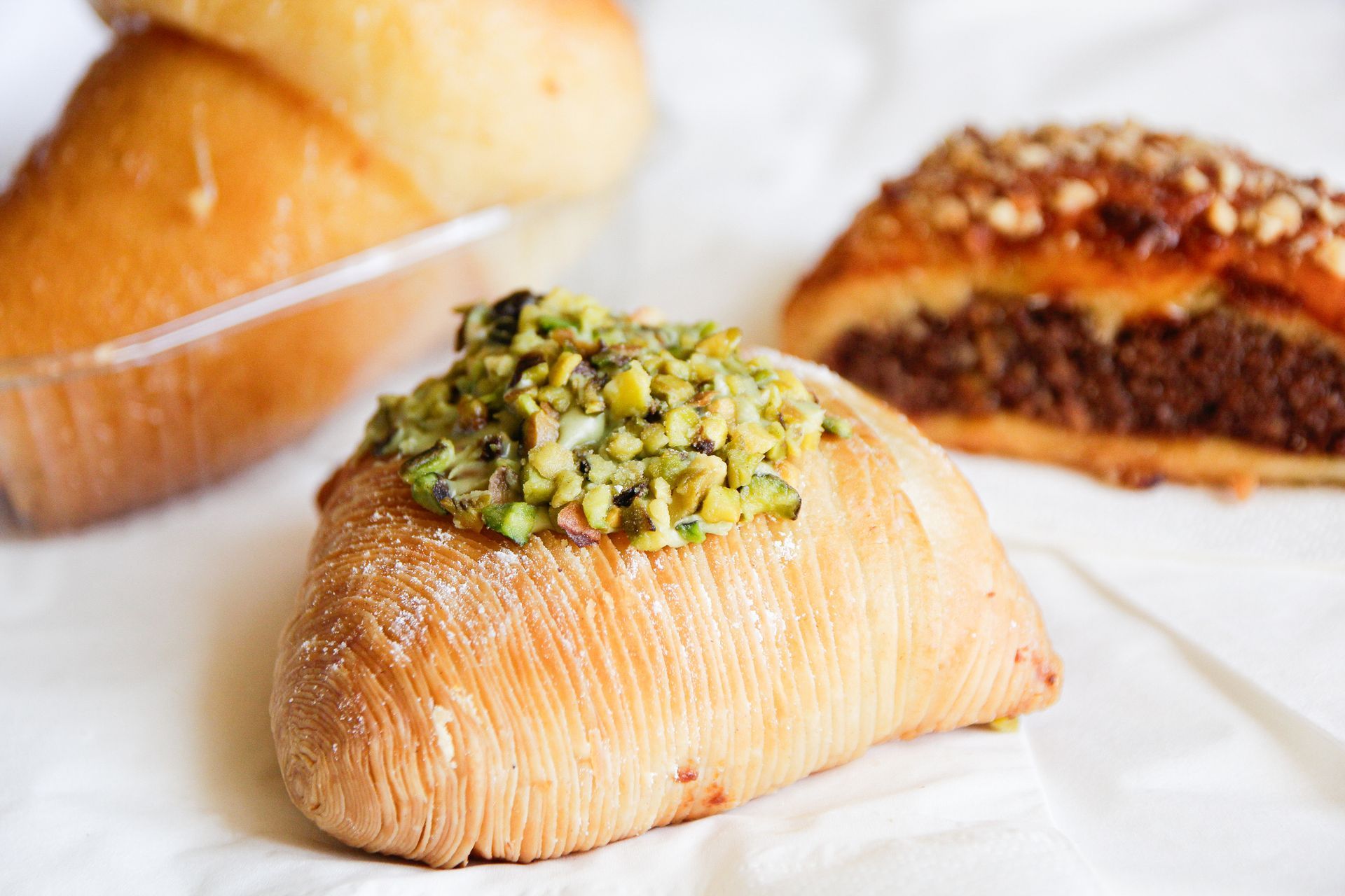 Tartare di manzo con tartufi su un piatto, cestino di pane, bicchiere d'acqua, sale, pepe e sacchetto.