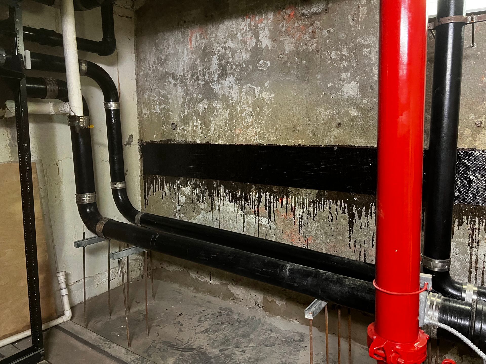 A room with a lot of pipes and a red pipe.