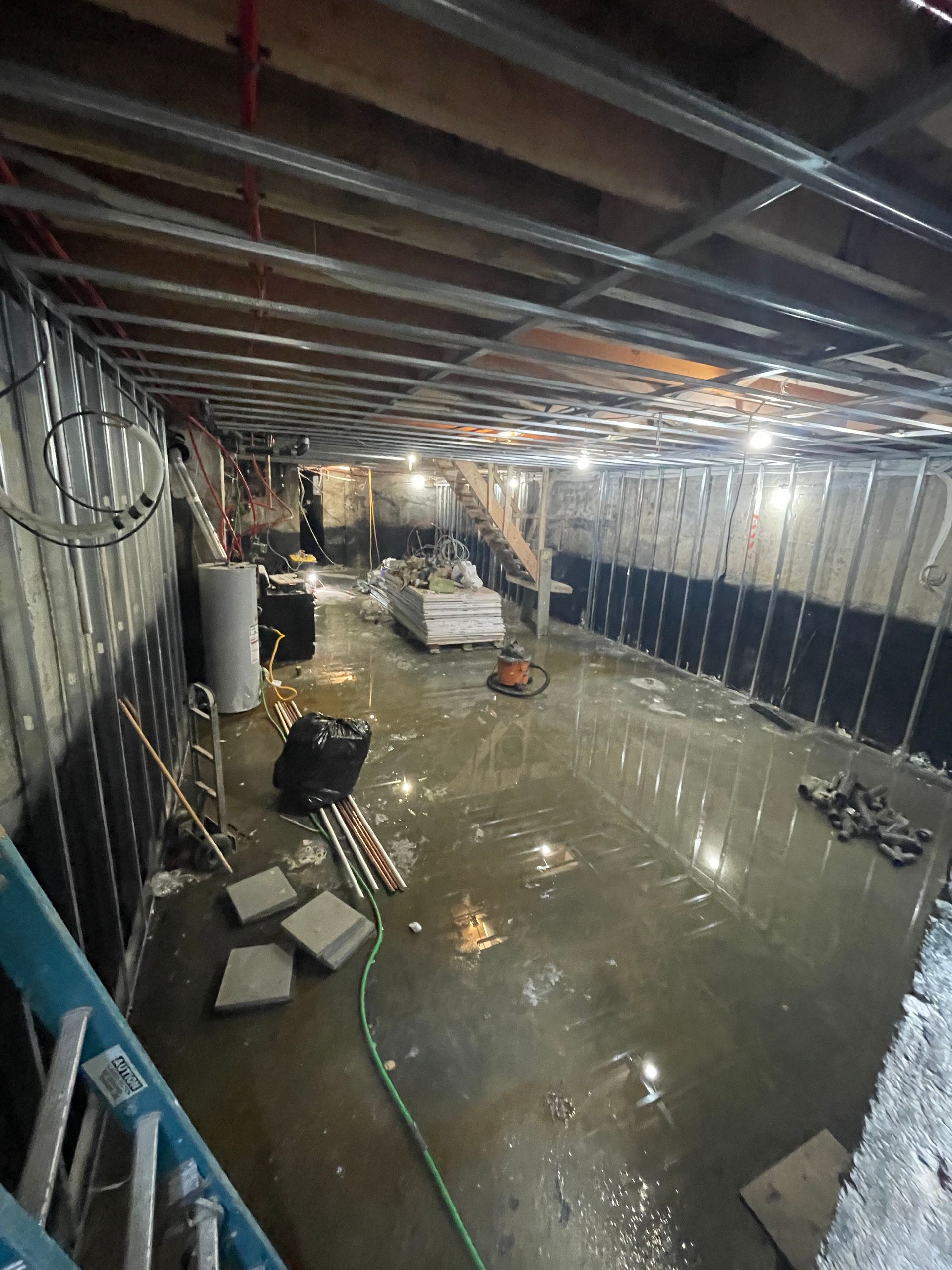 A flooded basement with a lot of water coming out of it.