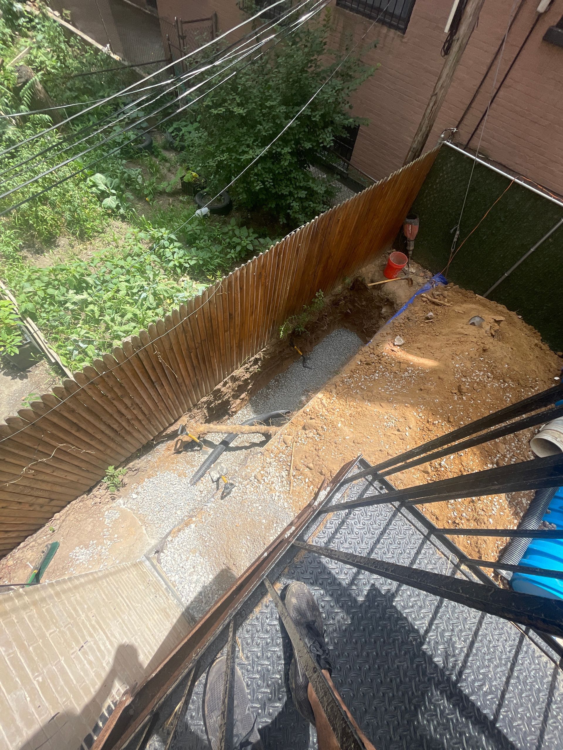 An aerial view of a backyard with a wooden fence and stairs.