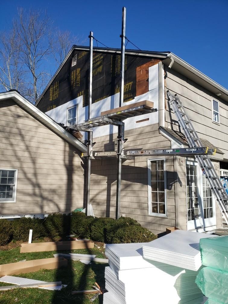 A house is being remodeled with a stack of styrofoam in front of it